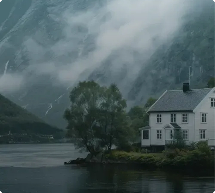 House near a lake with mountains in the background