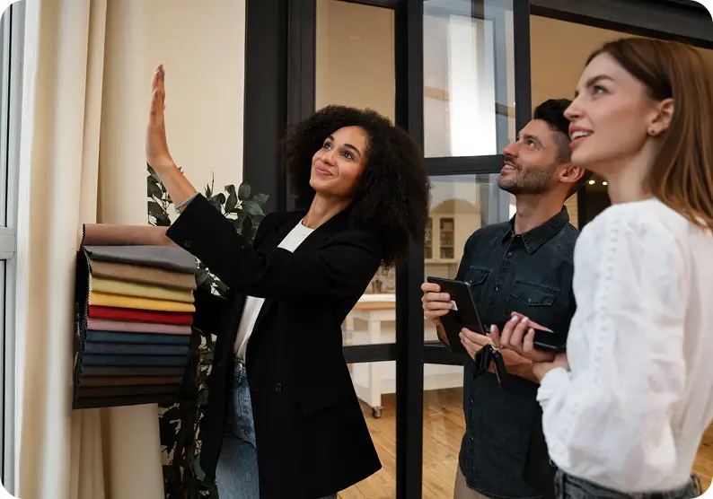 Three people looking at a wall while holding materials